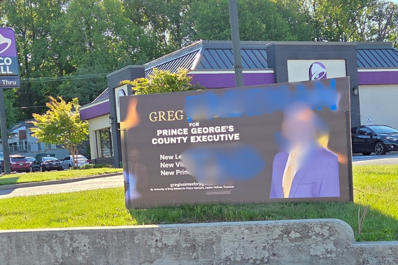 Blurred photo of vandalized campaign sign.