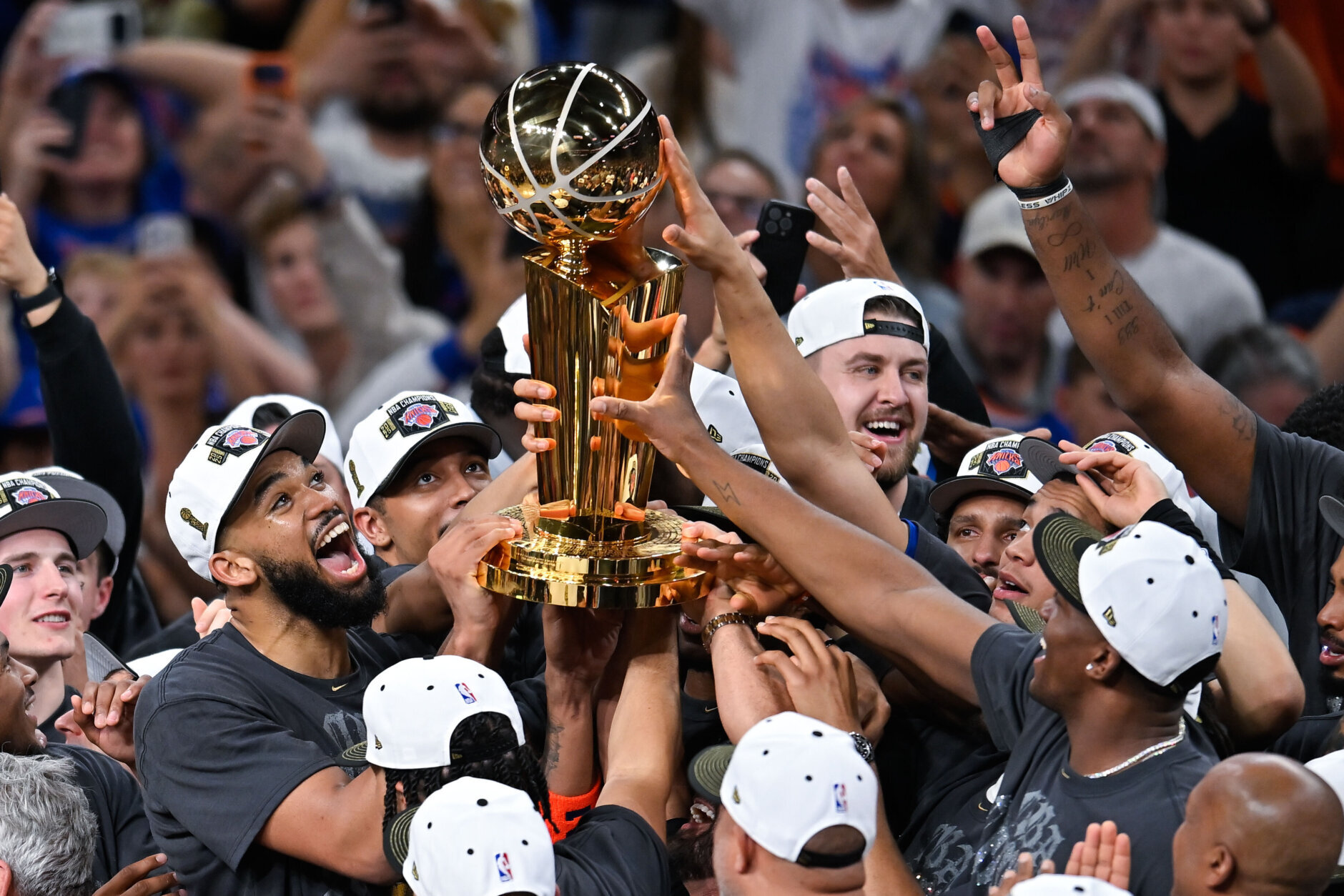 Los jugadores de los Knicks de Nueva York celebran con el trofeo de campeones de la NBA el Larry O'Brien después de derrotar a los Spurs de San Antonio en el quinto juego de las Finales de la NBA, el sábado 13 de junio de 2026, en San Antonio. (AP Foto/Darren Abate)