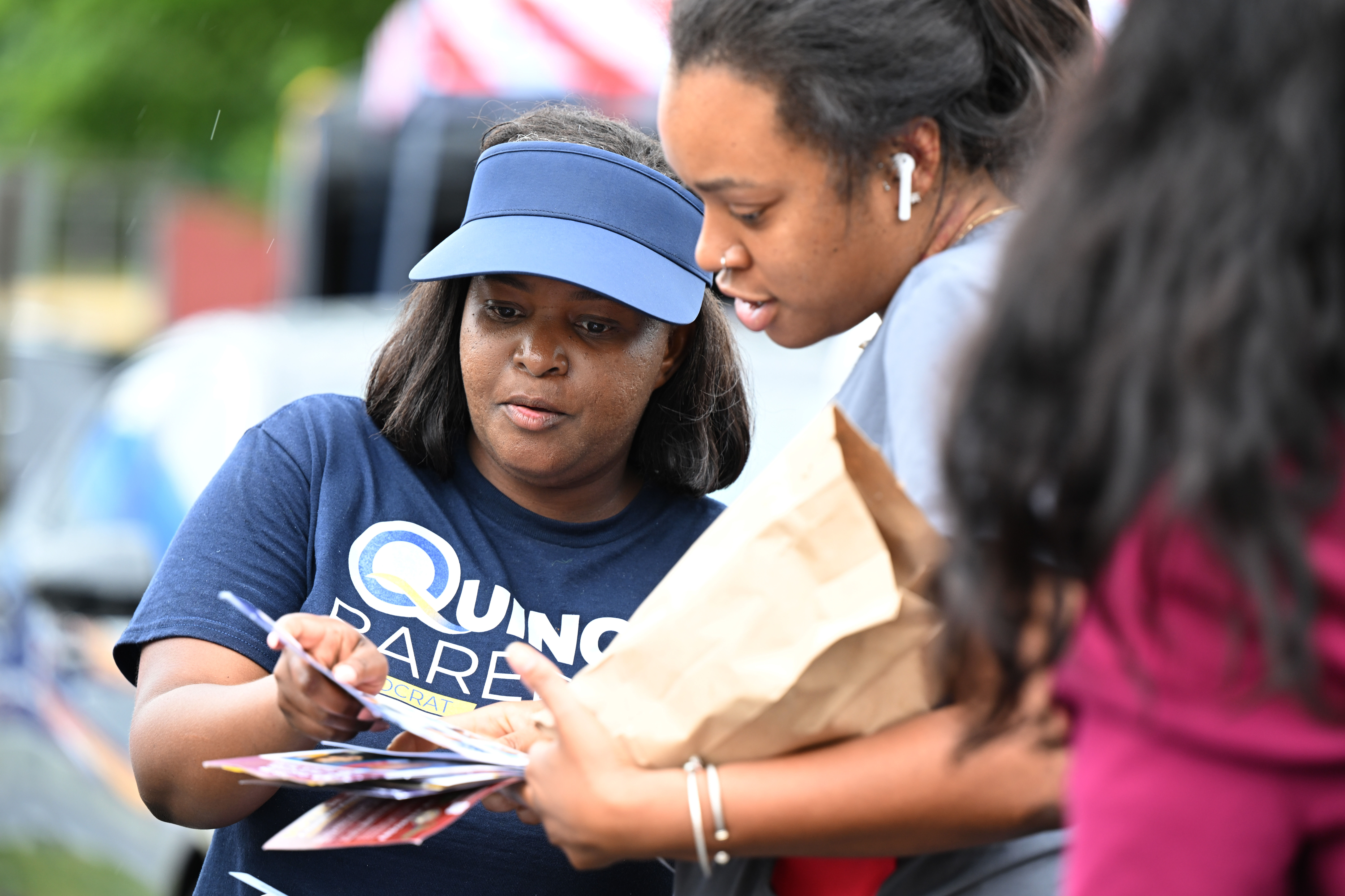 woman reviewing forms with another woman outside a polling place on election day