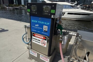 Gas pump on a dock with a large boat in background