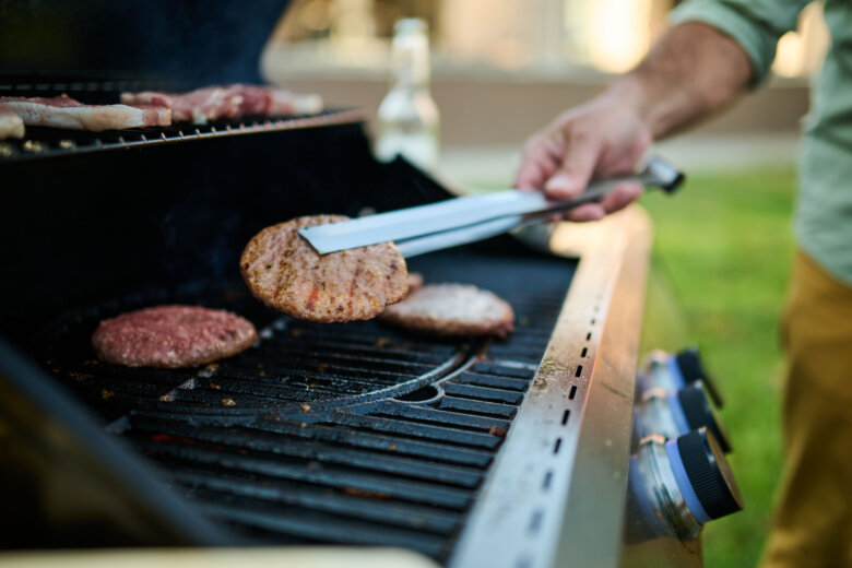Man grilling hamburgers and sausages