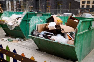 Overflowing green construction dumpster