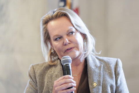 woman dressed formally speaking while holding mic