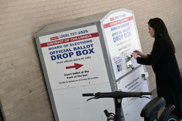 A person drops her ballot in a drop box at a polling place at the Martin Luther King Jr. Memorial Library during the D.C. primary elections on June 16, 2026, in Washington, D.C. (Photo by Brendan SMIALOWSKI/AFP via Getty Images)