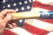 Baton held in front of U.S. flag.