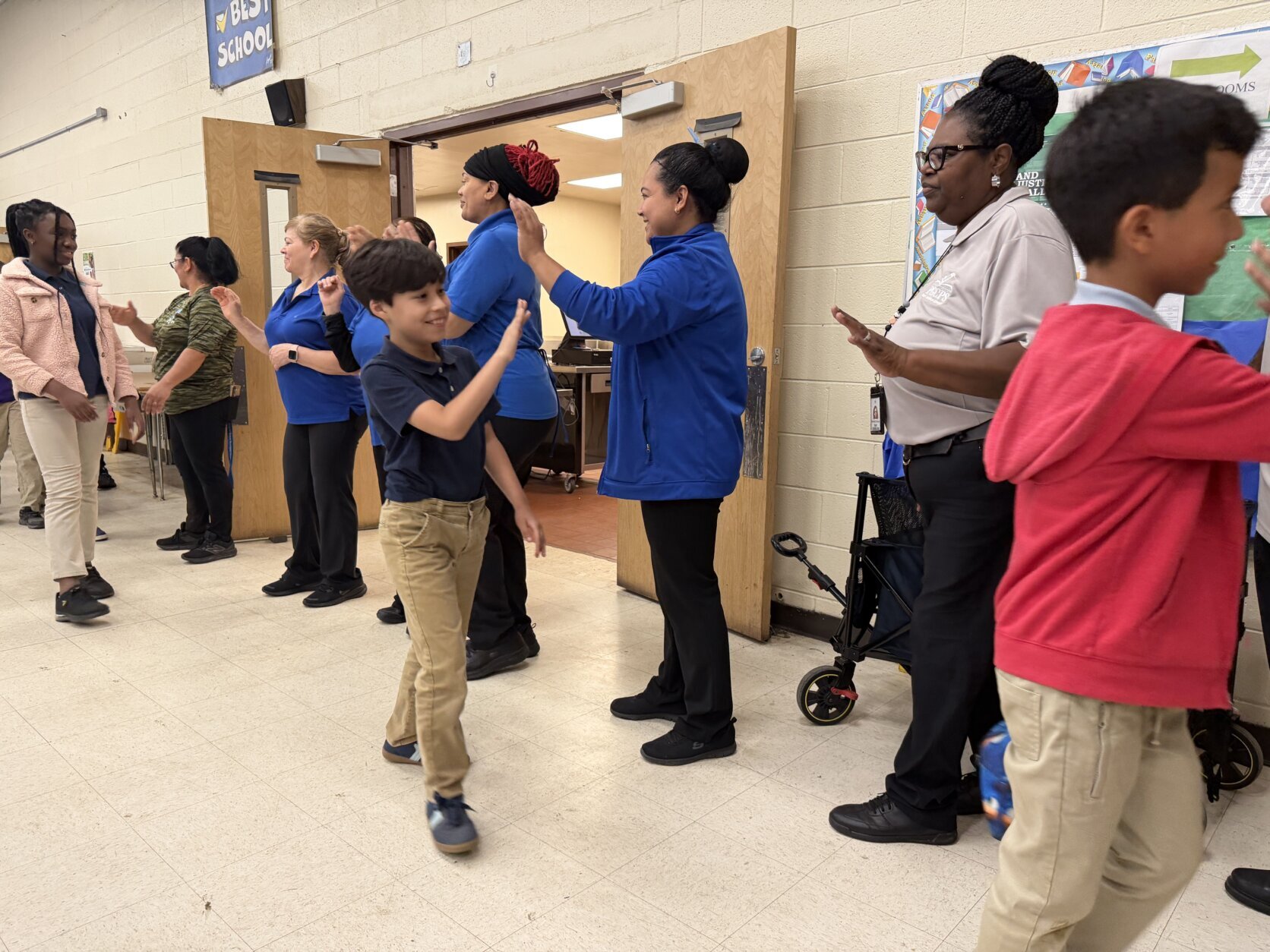 Students giving high-fives to cafeteria workers
