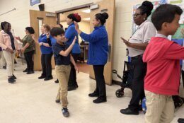 Students giving high-fives to cafeteria workers