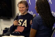 Illia speaking into a microphone wearing a USA sweater