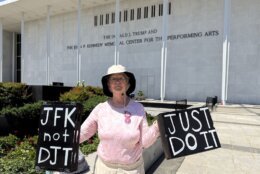 <p>A woman stands outside of the Kennedy Center as crews prepare to remove Donald Trump’s name from the building. (WTOP/Jimmy Alexander)</p>
