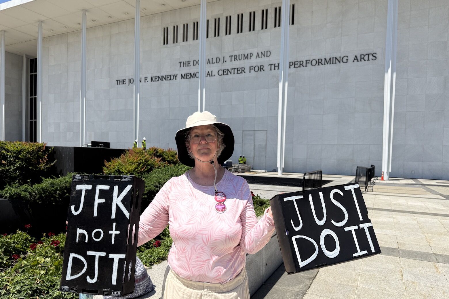 <p>A woman stands outside of the Kennedy Center as crews prepare to remove Donald Trump’s name from the building. (WTOP/Jimmy Alexander)</p>
