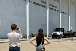 <p>People gather outside of the Kennedy Center as crews prepare to remove Donald Trump’s name from the building. (WTOP/Jimmy Alexander)</p>
