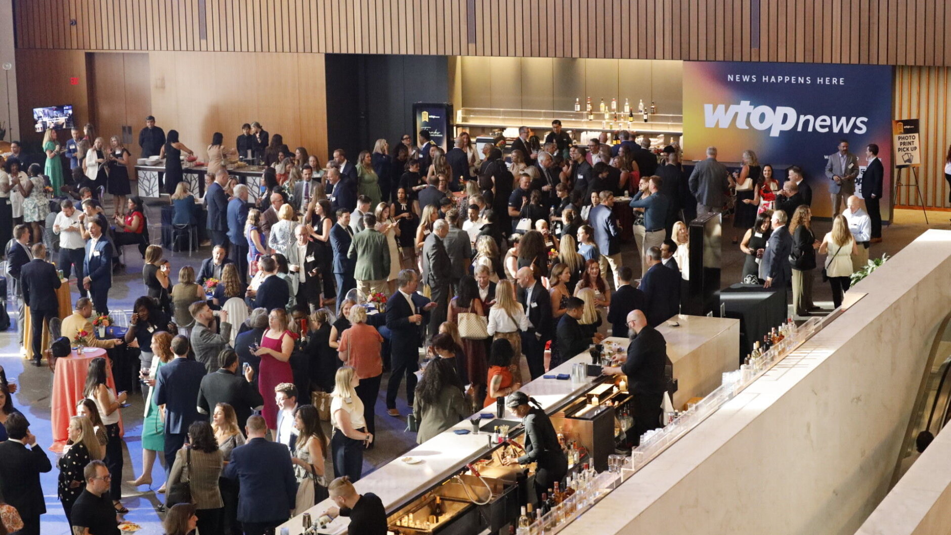 big crowd of people mingling over cocktails and small bites