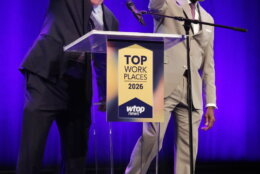 two men speaking at a podium on stage