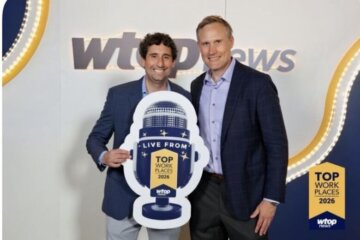 two men pose with award at press event