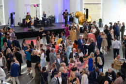 crowd of people while a band plays on a platform