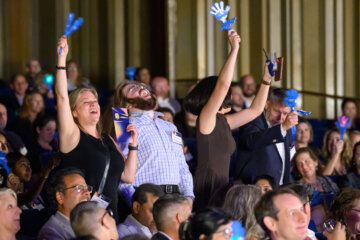 four people standing in crowd cheeing