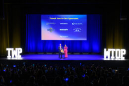 two people standing on stage from far away