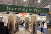 banner reading 'humanity in war' in large room