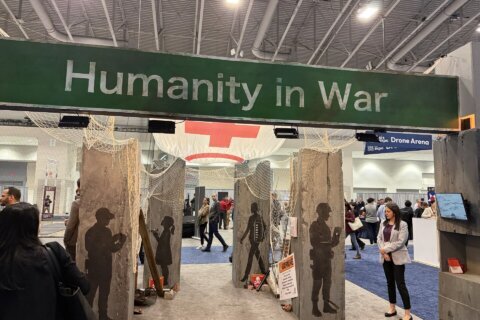banner reading 'humanity in war' in large room