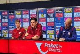 team speaks at news conference sitting at desk