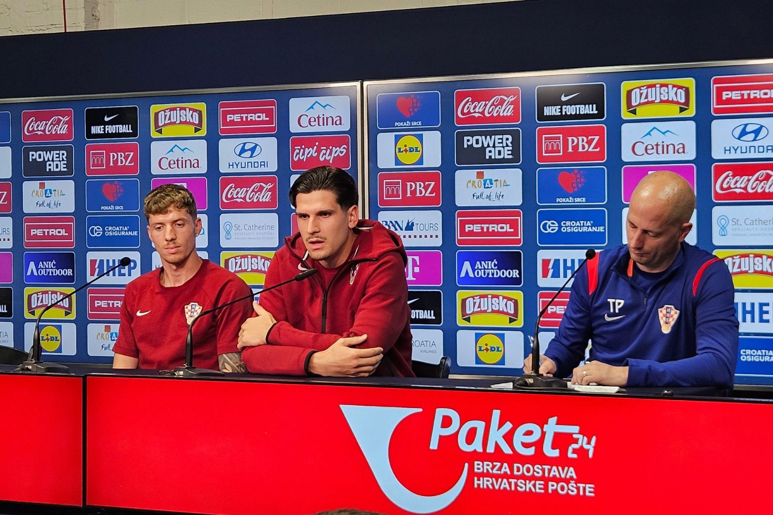 team speaks at news conference sitting at desk