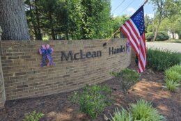 An alternate angle shows a flag and patriotic ribbon at the gates of McLean Hamlet.