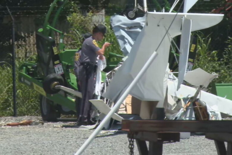 authorities standing by wreckage of small plane