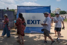 Attendees exit the grounds of the Great American State Fair after the event was closed for the afternoon due to extreme heat on the National Mall, Friday, July 3, 2026, in Washington. (AP Photo/Nathan Howard)