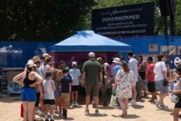 Attendees exit the grounds of the Great American State Fair after the event was closed for the afternoon due to extreme heat on the National Mall, Friday, July 3, 2026, in Washington. (AP Photo/Nathan Howard)