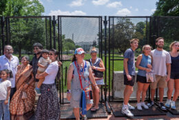 Independence Day holiday visitors endure sweltering temperatures as they try to get a view of the White House beyond metal fencing surrounding Lafayette Park, in Washington, Friday, July 3, 2026. (AP Photo/J. Scott Applewhite)