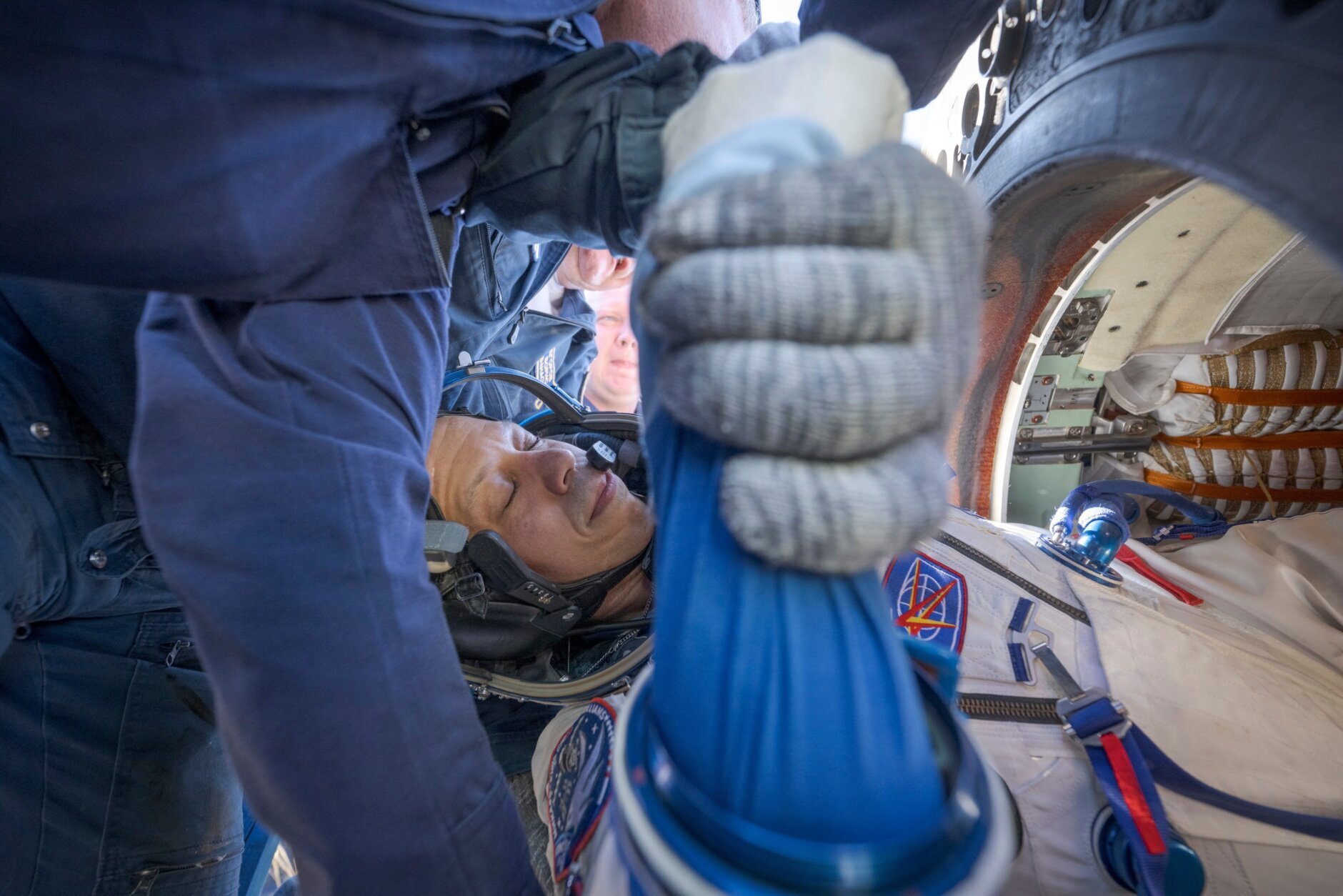 NASA astronaut Chris Williams is helped out of the Soyuz MS-28 spacecraft just minutes after he and Expedition 74 Roscosmos cosmonauts Sergey Kud-Sverchkov, and Sergei Mikaev landed in a remote area near the town of Zhezkazgan, Kazakhstan on Sunday, July 26, 2026. (Bill Ingalls/NASA via AP)