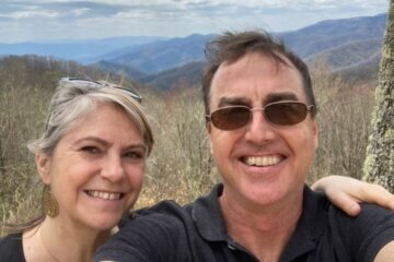 David Peterson and his wife with mountains in the background