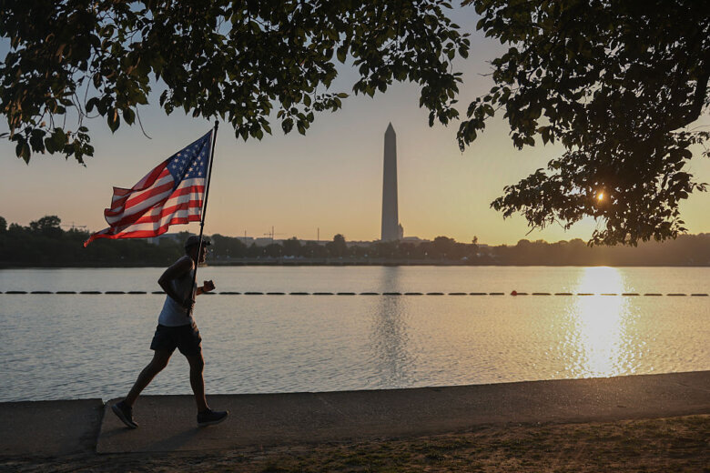 Pete Folch carries an American flag during a morning run along the Tidal Basin
