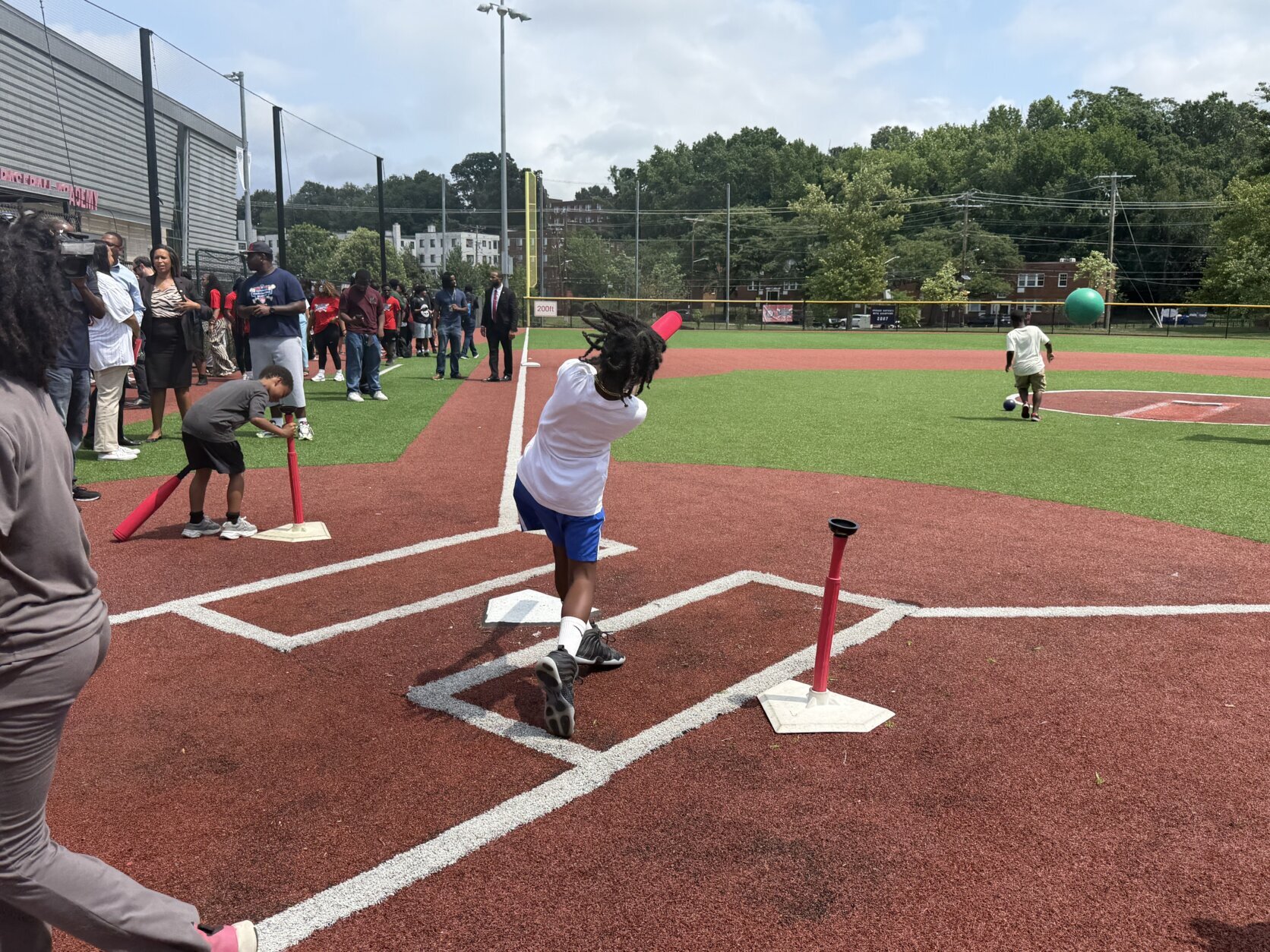 Kid hits ball off of T-ball stand