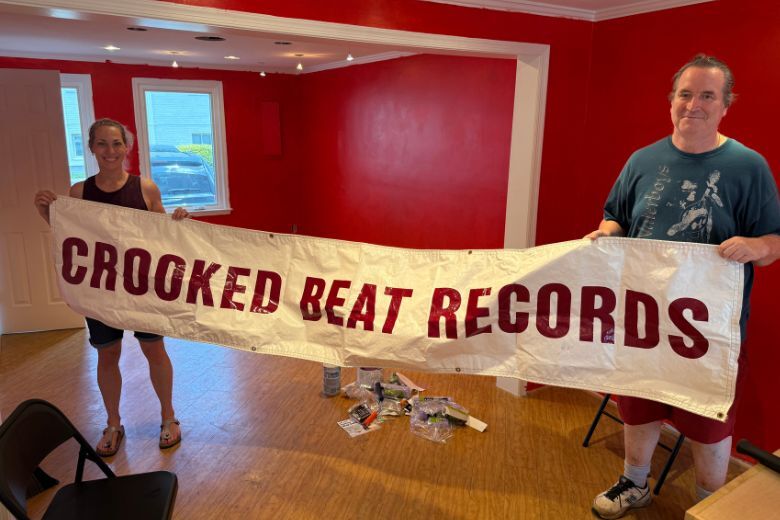 employees hold sign that says crooked beat records
