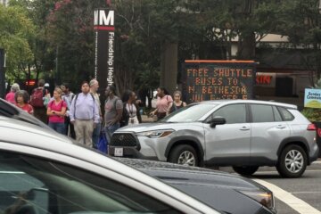 Riders prepare to board shuttle buses near the Friendship Heights station