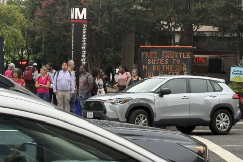 Riders prepare to board shuttle buses near the Friendship Heights station