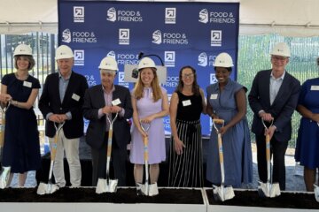 officials wearing hardhats and holding shovels during facility groundbreaking ceremony