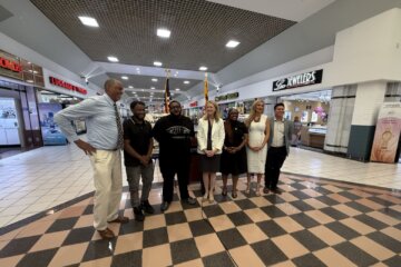 officials pose for photo in group in mall