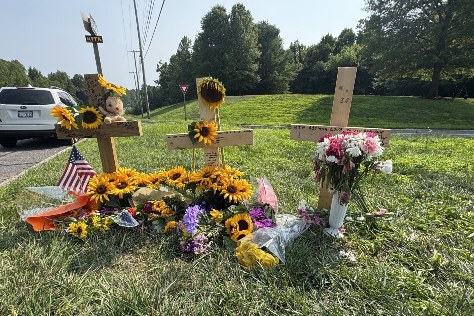 memorial on side of road featuring crosses and flowers at the site of a deadly car crash