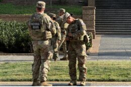national guard troops stand in park