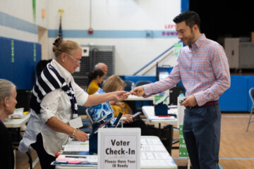 A voter checks in at Lyles-Crouch Traditional Academy for the Virginia primary election, Tuesday, Aug. 4, 2026, in Alexandria, Va. (AP Photo/Allison Robbert)