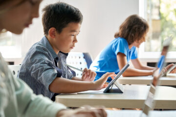 boy uses tablet during lesson