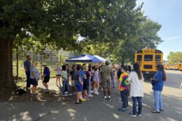 students gathered by a school bus