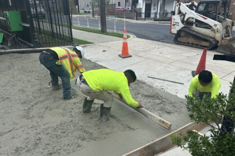 workers flatten liquid concrete