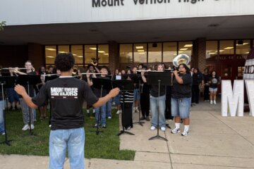 school band performs in front of high school in casual wear