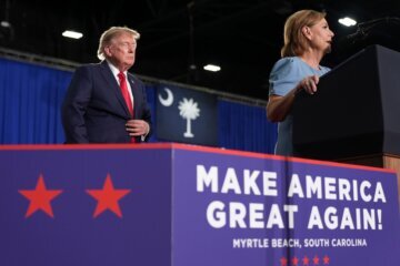 Darline Graham speaks as President Donald Trump listens at a campaign rally