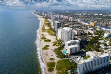 a view from overhead of a resort coastal urban environment by the beach